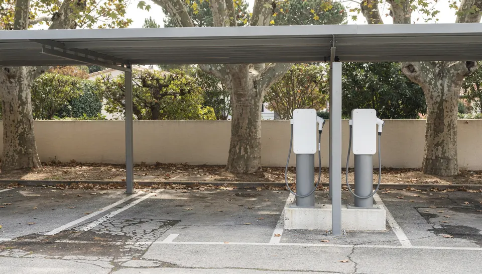 Deux bornes de recharge sur pied sous l'abri d'un parking extérieur de résidence